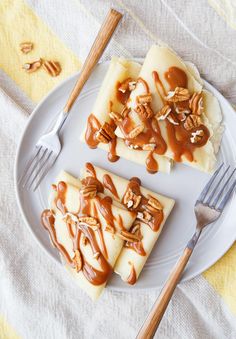 three pieces of cheesecake with caramel drizzled on top and pecans in the background