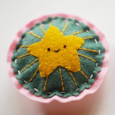 a small cupcake with a yellow star on it's top and pink bottom