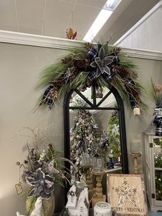 a mirror sitting on top of a table covered in christmas decorations and greenery next to other items