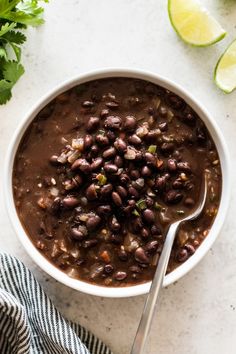 a white bowl filled with beans and garnished with cilantro