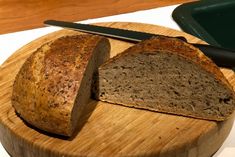 a loaf of bread sitting on top of a wooden cutting board next to a knife