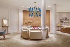 the inside of a jewelry store with chandelier and counter tops in beige tones