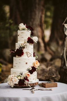 a wedding cake sitting on top of a table next to a knife and some flowers