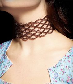 a close up of a woman's neck wearing a necklace with beads on it