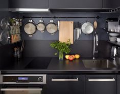 a kitchen with black cabinets and stainless steel appliances