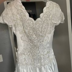 a white wedding dress hanging on a hanger