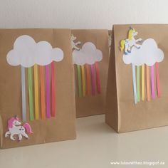 three brown paper bags with unicorns and rainbow sticks on them, one has a white horse