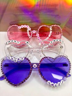 CUSTOM SHORT N SWEET SUNGLASSES COMPLETELY CUSTOMIZABLE: 3 letter layouts available, mix and match colors, option to include city or "tour" (for example: Short N Sweet Tour, Short N Sweet Philly) Rhinestone Bedazzled Sunglasses Available in pink, purple, clear, blue, black, and others by request (please DM) Several design & word options available Concert Sunglasses, Bedazzled Sunglasses, Carpenter Outfits, Beaded Sunglasses, Disco Birthday Party, Sabrina Carpenter Outfits, Sunglasses Design, Rave Accessories, Match Colors