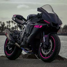 a black motorcycle parked next to the water