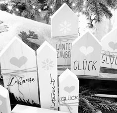 christmas decorations made from wooden pickets and snowflakes are displayed in black and white