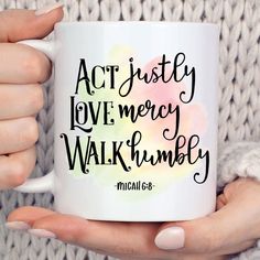 a woman holding a white coffee mug with the words act justly love mercy walk humbly