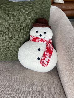 a snowman pillow sitting on top of a couch