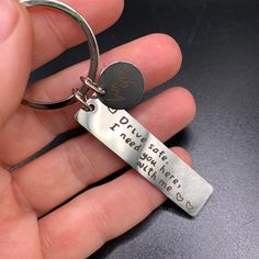 a person holding a key chain with a quote on it