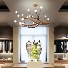 a room filled with lots of clothes on display in front of a chandelier