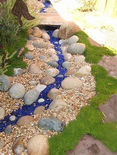 a garden with rocks and water running through it