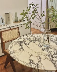 a table with a vase on it and a plant in the middle, next to an oven