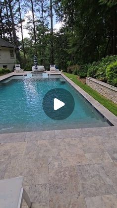 a swimming pool surrounded by landscaping and trees