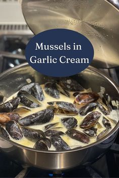 mussels in garlic cream being cooked in a pot on the stove with text overlay