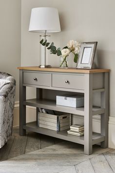 a living room with a couch, table and lamp on it's sideboard