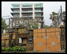 an old building with lots of windows and graffiti on the wall next to a gate