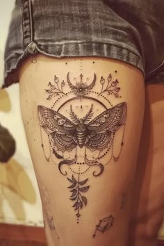 a woman's thigh with a moth tattoo on it