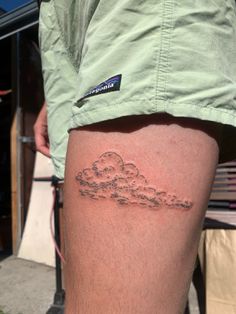 a man with a cloud tattoo on his thigh