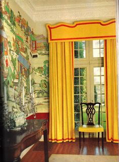 the room is decorated in yellow and red with a wallpapered mural behind it