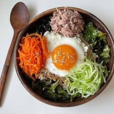 a bowl filled with meat, vegetables and an egg