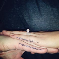 two people holding hands with tattoos on their fingers and the words dynamite written in cursive writing