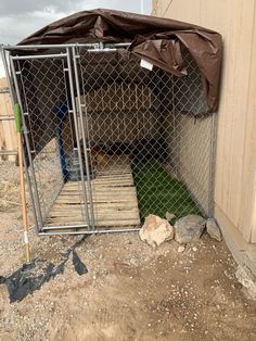 a dog kennel in the middle of dirt and rocks