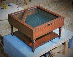 a wooden table sitting on top of a blue cushion