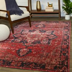 a living room with a red rug and chair