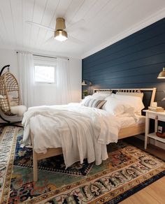 a white bed sitting in a bedroom on top of a rug