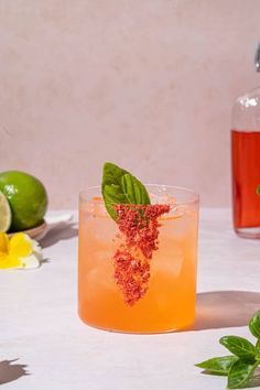 a glass filled with liquid next to some lemons