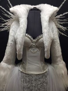 a white dress and jacket with feathers on it