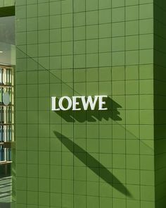 a green building with the name loewf on it's side and bookshelves in the background