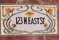 a tile sign with flowers on it that says, 13 n east