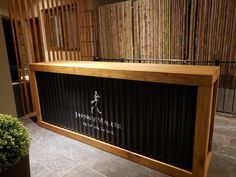 a large wooden bar sitting on top of a tiled floor next to a potted plant