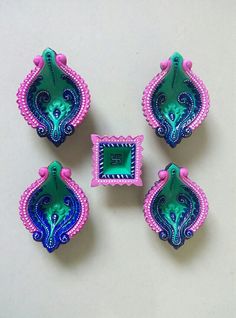 four pieces of bead work on a white surface with pink and green trimmings