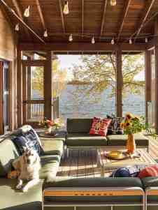 a living room filled with lots of furniture next to a large window covered in wood