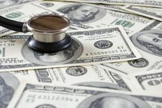 a stethoscope sitting on top of a pile of money