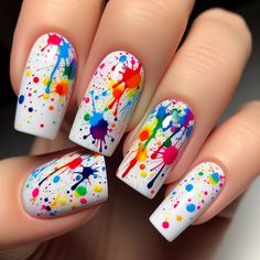 The nails are painted with a solid white base. Over this base, splatters of rainbow colors are randomly applied using a splatter technique. The result is a vibrant, abstract design that looks like a burst of color. A glossy top coat adds a smooth finish. Smiley Face Design Nails, Black Paint Splatter Nails, Neon Paint Splatter Nails, Color Splash Nails, Neon Gel Nails Short, Trans Pride Nails, 80s Nails 1980s, Edc Nails Designs