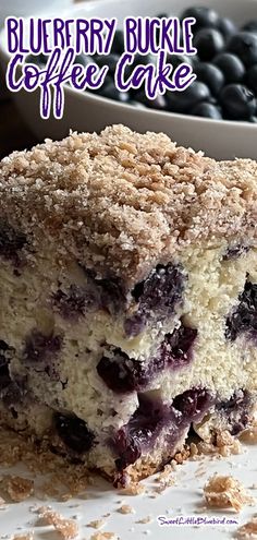 a close up of a piece of cake on a plate with berries in the background