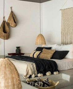 a bed room with a neatly made bed and baskets hanging on the wall above it