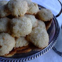 a plate full of sugar cookies next to a cup of coffee