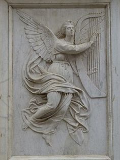 an angel holding a harp on the side of a building