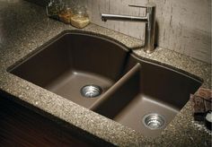 an image of a kitchen sink with granite counter top and brown color finish on it