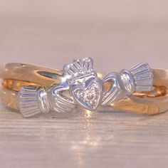 The Doolin: Irish Made Claddagh Ring With Natural Diamonds. This Ring Boasts A Unique Twisted Split Shank Design, With One Section Featuring The Classic Claddagh Motif At The Center, Topped With Rhodium For Added Shine. Adorning The Heart Of The Claddagh Is A Single Round Brilliant-Cut Natural Diamond, Weighing 0.01 Carats. Meticulously Crafted In 14 Karat Yellow Gold, The Ring Is Currently Sized At 5, With The Option For Adjustment To Any Finger Size Available For An Additional Charge Upon Request. Made In Ireland, It Proudly Bears Its Original Irish Hallmarks And Is Signed By Its Esteemed Irish Designer, Solvar, Reflecting Its Authenticity And Heritage. The Claddagh Ring Is A Traditional I Diamond Claddagh Ring, Claddagh Ring Wedding, Irish Symbols, Claddagh Ring, Claddagh Rings, Irish Heritage, Irish Traditions, Split Shank, Love Symbols