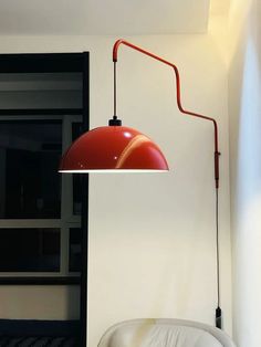 a red lamp hanging over a bed in a room