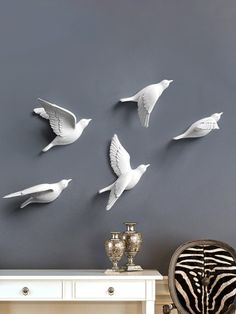 several white birds are flying in the air above a table and zebra print chair next to it